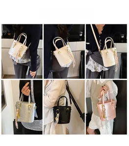 Detail of a stylish bucket bag in four colors with scarf and metal buckle strap