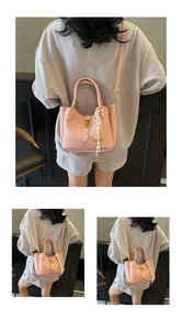 Dettaglio borsa a secchiello in pelle litchi rosa con foulard e chiusura a girello