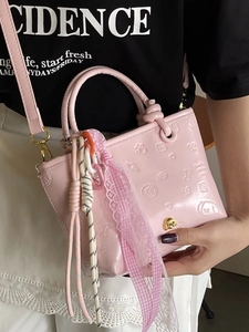 Sac seau en cuir verni rose avec motifs gaufrés et bandoulière réglable pratique