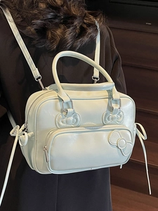 Chic mint green Boston bag with bow details, showing versatile backpack and handbag style