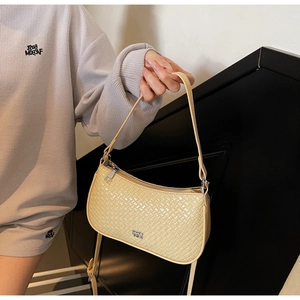 Close-up of cream woven texture underarm bag with silver zipper and metal logo