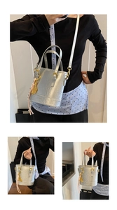Detail showing metallic silver bucket bag with gold tennis racket charm and thin straps