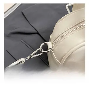 Detail view of the silver metal hook and D-ring on the beige leather Boston bag