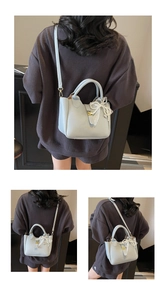 Detail of light blue bucket bag with gold lock and pearl lace bow charm