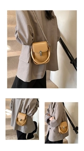 Detailed macro view of camel PU leather crossbody bag featuring silver metal buckle and chain