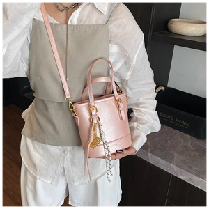 Pink bucket bag with lychee texture featuring double handles and black-white rope detail