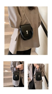 Detail of minimalist black crossbody bag with silver cylindrical lock and chain strap