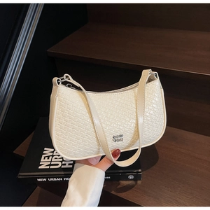 Detail of cream white underarm bag with diamond woven texture and gold metal logo