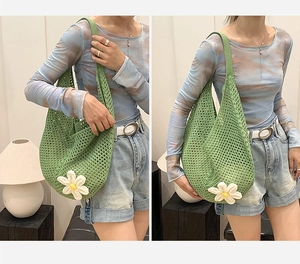 Detail of green knit hollow mesh tote bag featuring a white daisy flower decoration
