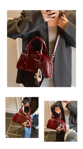 Three-way view of deep red glossy patent leather Boston bag with teddy bear and pearl charms