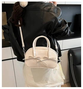 Vue arrière d'un sac Boston blanc à nœuds avec bandoulière porté par un mannequin