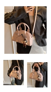 Detailed view of pink patent leather Boston bag with round handles and cartoon charm