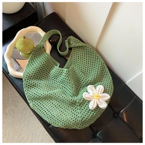 Detail of light green crochet woven tote bag featuring a 3D floral accent and hollow pattern