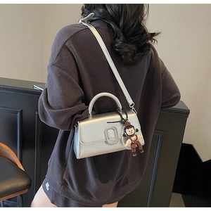 Detail of silver metallic square bag with U-shaped buckle and pearl cartoon charm