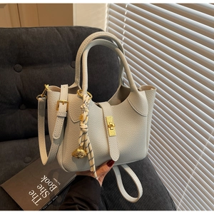 Dettaglio della borsa a secchiello in pelle blu chiaro con motivo litchi e fibbia oro