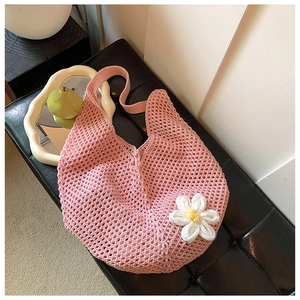 Detailed close-up of pink crochet tote bag with a white 3D knit daisy flower accessory
