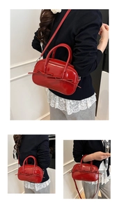 Sac Boston en cuir verni rouge avec nœuds décoratifs et détails de bandoulière polyvalents