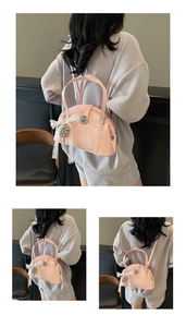 Détails d'un sac à main rose avec nœud en dentelle, perles et fermoir métallique poli