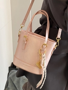 Chic pink pearlescent bucket bag with gold hardware and tassel detail for women
