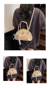 Détail du sac coquillage en cuir verni brillant avec breloque cœur perlé et fermoir
