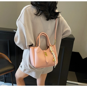 Dettaglio della borsa a secchiello in pelle rosa con foulard e chiusura dorata
