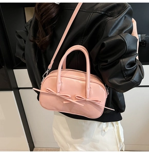 Détail du sac Boston rose avec design à double nœud et quincaillerie en métal argenté