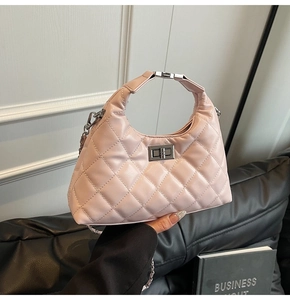 Dettaglio borsa in pelle trapuntata rosa con chiusura a rotazione argento e tracolla a catena