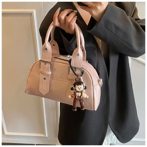 Detail of light pink patent leather Boston bag with cute cartoon charm and studs