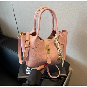 Borsa a mano rosa con trama litchi, chiusura a scatto dorata e ciondolo a forma di orso