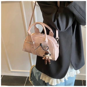 Pink patent leather Boston bag with a cute doll pendant and silver metal buckle details