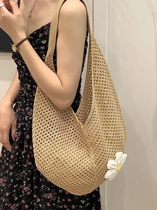 Beige hollow straw shoulder bag with white daisy detail shown on a female model