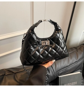 Dettaglio borsa hobo nera trapuntata con chiusura a scatto argento e tracolla a catena