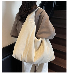 Borsa hobo oversize minimalista bianco crema vista dal retro sulla spalla di una modella