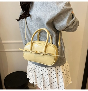 Vue détaillée du sac Boston jaune crème avec nœud porté par un mannequin pour le style