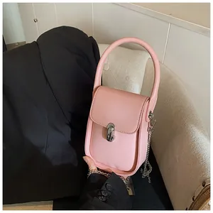 Detail of light pink mini leather handbag with silver metal swivel lock and chain strap