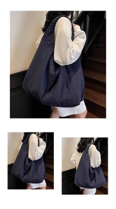Dettaglio di una borsa tote imbottita blu scuro con trama trapuntata e ampia tracolla