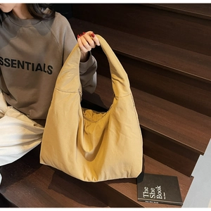 Dettaglio della grande borsa hobo kaki in tessuto morbido per un look casual quotidiano