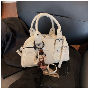 Creamy white Boston handbag with shiny PU leather texture and a cute charm detail
