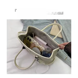Vue de dessus d'un sac seau en cuir grainé blanc montrant l'espace intérieur et le rangement