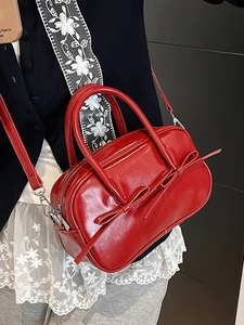 Sac Boston en cuir rouge brillant avec nœuds décoratifs et bandoulière réglable