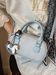 Elegante borsa a bauletto azzurra con trama litchi, ciondolo a cavallo e sciarpa in seta