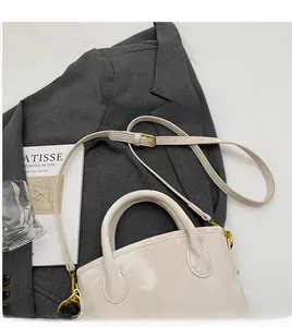 Detail of smooth adjustable long shoulder strap and golden metal buckle on bucket bag