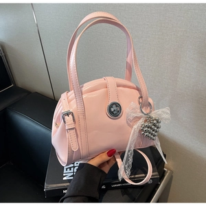 Détail du sac à main rose avec fermoir rotatif argenté et charmant cœur en dentelle chic