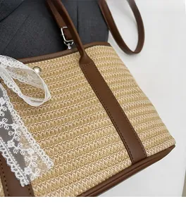 Gros plan détaillé du sac seau en paille avec garniture en cuir brun et dentelle blanche