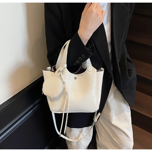 Sac seau blanc motif crocodile avec mini porte-monnaie porté par un mannequin