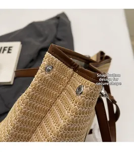 Détail des boutons-pression argentés et de la texture tressée du sac seau en paille