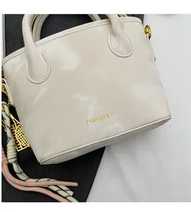 Close-up of off-white bucket bag featuring soft leather texture and golden ring hardware