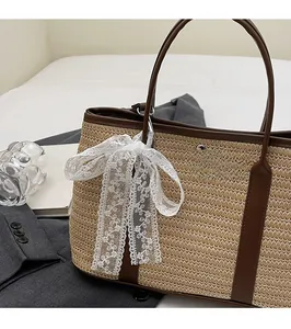Détail du sac cabas en paille tissée avec garniture en cuir et nœud en dentelle