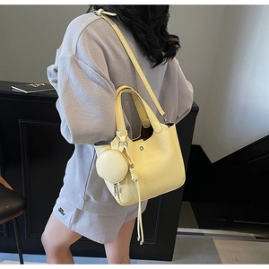 Vue détaillée du sac seau jaune à motif crocodile avec petit porte-monnaie rond