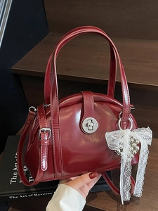Sac docteur rétro bordeaux avec finition brillante et charme en dentelle sur bois sombre